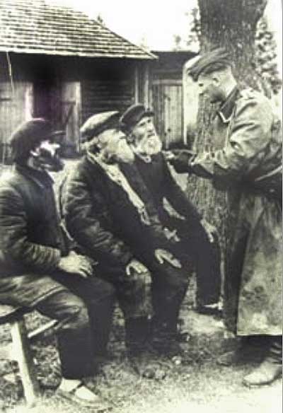 Немецкий солдат в осажденной Старой Руссе знакомится с местными жителями.